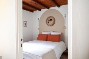 a bedroom with a white bed with orange pillows at Les Terrasses du Maquis in Nonza