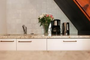 a kitchen counter with a vase of flowers on it at Les Terrasses du Maquis in Nonza