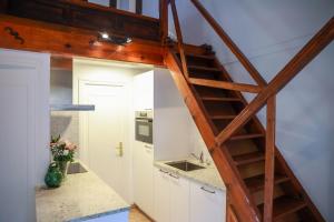 a kitchen with a staircase leading up to a loft at Les Terrasses du Maquis in Nonza +47 photos