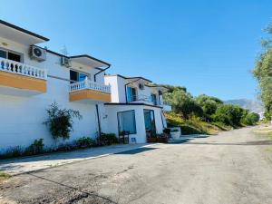 a large white house with a driveway at Donald Hotel in Vlorë