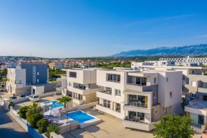 an aerial view of a white apartment building at Apartments & Rooms Danivan Pool Villas - Off site breakfast available in Novalja