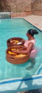 a woman sitting in a pool in a swimming pool at Epic touch B&B in Sandton
