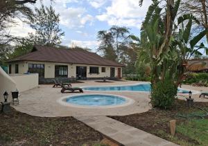a swimming pool in front of a house at Sweetwaters Serena Camp in Nanyuki
