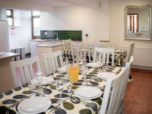 a dining room with a table with plates and glasses at Whitehouse Farm in Hartington
