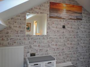 a bathroom with a stone wall with a mirror at Holly's Apartment in Beverley +10 photos