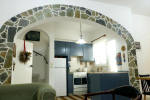 a kitchen with an archway in the middle of a room at Arco In Pietra in Apolakkiá