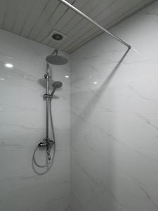 a shower in a bathroom with white marble walls at AlvinaMI in Tsaghkadzor +3 photos