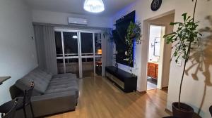 a living room with a gray couch and a large window at Prince 1513 in Vitória +6 photos