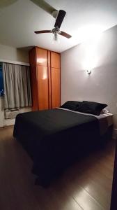 a bedroom with a black bed and a ceiling fan at Prince 1513 in Vitória