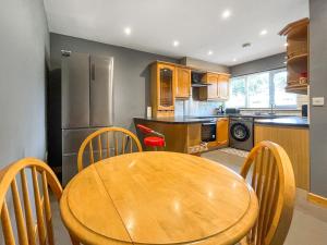 a kitchen with a wooden table and chairs at Orcadians in Sellindge