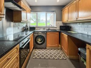 a kitchen with a washing machine in the middle at Orcadians in Sellindge