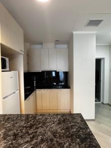 a kitchen with white cabinets and a black counter top at AlvinaMI in Tsaghkadzor