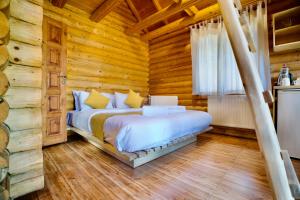 a bedroom with a bed in a log cabin at Wood Hills Hotel & Resort in Mayrūbā