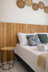 a bedroom with a bed and a wooden wall with plates at Pousada Familiar I 5 min de carro do centrinho I Piscina, café e estacionamento in Paraty +63 photos