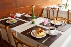 a table with plates of food and cups of coffee at Pampulha Flat in Belo Horizonte