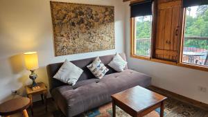 a living room with a couch and a table at Le Ville - Campos do Jordão in Campos do Jordão