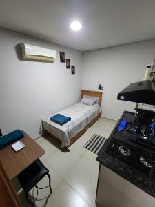 a room with a bed and a kitchen in it at Studio Aconchegante in Lins