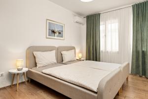 a bedroom with a large bed with green curtains at Gortanova Bay Maisonette in Pula