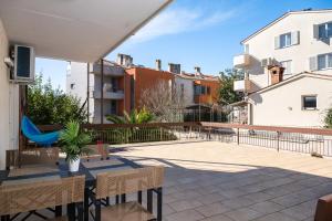 a balcony with a table and chairs and buildings at Gortanova Bay Maisonette in Pula