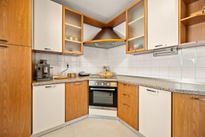 a kitchen with white appliances and wooden cabinets at Gortanova Bay Maisonette in Pula