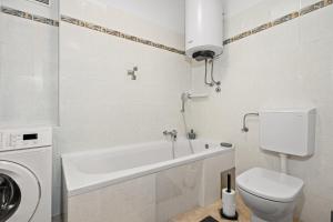 a bathroom with a toilet and a washing machine at Gortanova Bay Maisonette in Pula +30 photos