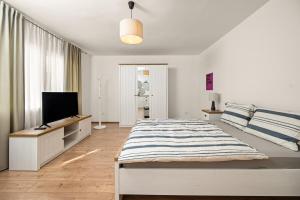 a bedroom with a bed and a flat screen tv at Gortanova Bay Maisonette in Pula