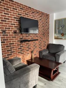 a living room with two couches and a brick wall at Casa Crăciun in Mănăstirea Humorului