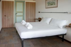 a bedroom with a white bed with towels on it at Semivaganti Agritur in Candelara +14 photos