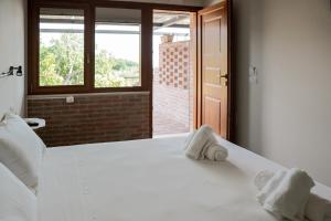 a bedroom with a white bed with towels on it at Semivaganti Agritur in Candelara