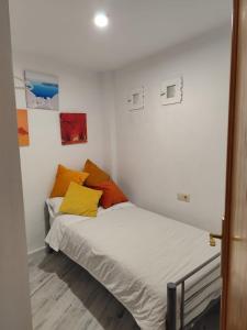 a bedroom with a bed with orange and yellow pillows at Reyes in Monachil