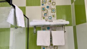 a bathroom with white towels on a green wall at Hotel Zava Boutique - City Center in Bucharest +31 photos