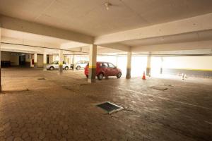 a parking garage with a red car parked in it at Pampulha Flat in Belo Horizonte +29 photos