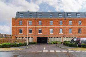 a large red brick building with a parking lot at iDeal Apartment by Keepers Cottages in Deal