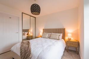 a bedroom with a large white bed and a mirror at iDeal Apartment by Keepers Cottages in Deal