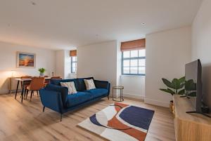 a living room with a blue couch and a table at iDeal Apartment by Keepers Cottages in Deal