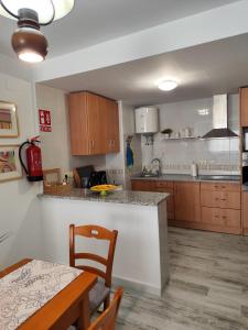 a kitchen with wooden cabinets and a table and a dining room at Reyes in Monachil +14 photos