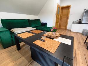 a living room with a green couch and a table at Gajówka Świt in Łyskowo