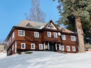 a large wooden house sitting in the snow at Chata Jablunka, Dog friendly, 50m ski slope, 50m restaurant in Pec pod Sněžkou +4 photos
