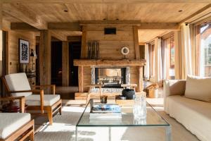 a living room with a table and a fireplace at L'Alpaga, a Beaumier hotel in Megève