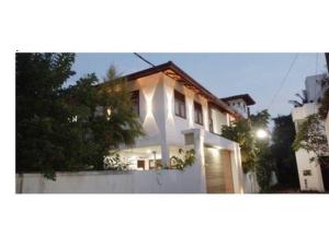 a white house with a fence in front of it at Spacious 4BR Green Court Villa for 8-10 Guests AC & Hot Water Thalawathugoda in Talawatugoda