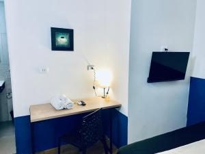 a room with a desk with a lamp and a chair at Studiohaus Pertence in São Paulo