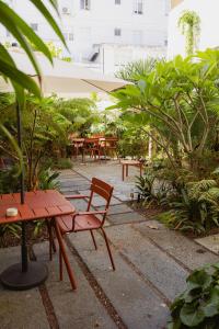 a patio with a bench and tables and plants at NINE DOTS Azorean Art Boutique Hotel in Ponta Delgada