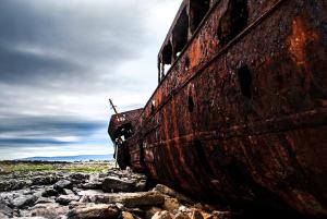 an old ship sitting on some rocks at The Old Post Office Holiday Home, Dunmore in Galway +1 photo