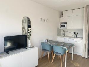 a kitchen with a table and chairs and a television at Studio à 2 pas de la plage! in Hossegor