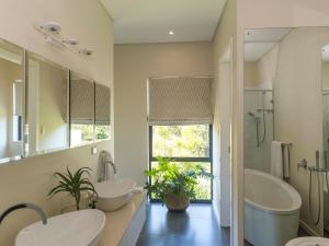 a bathroom with two sinks and a large mirror at Luxury Villa Rainbow, Eden Rock Estate, Pennington in Pennington