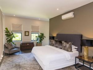 a bedroom with a white bed and a chair at Luxury Villa Rainbow, Eden Rock Estate, Pennington in Pennington