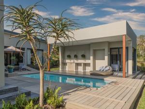 a house with a swimming pool and a palm tree at Luxury Villa Rainbow, Eden Rock Estate, Pennington in Pennington
