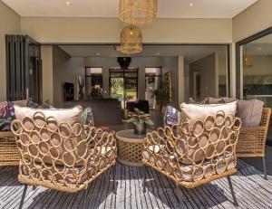 a living room with wicker chairs and a table at Luxury Villa Rainbow, Eden Rock Estate, Pennington in Pennington