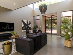 a living room with black leather furniture and a chandelier at Luxury Villa Rainbow, Eden Rock Estate, Pennington in Pennington +18 photos