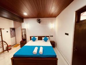 a bedroom with a bed with slippers on it at Vihen Homestay in Dickwella